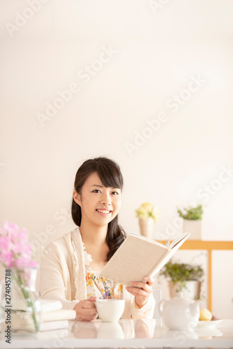本を持ち微笑む女性