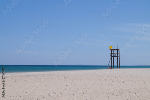beach with blue water and lifeguard