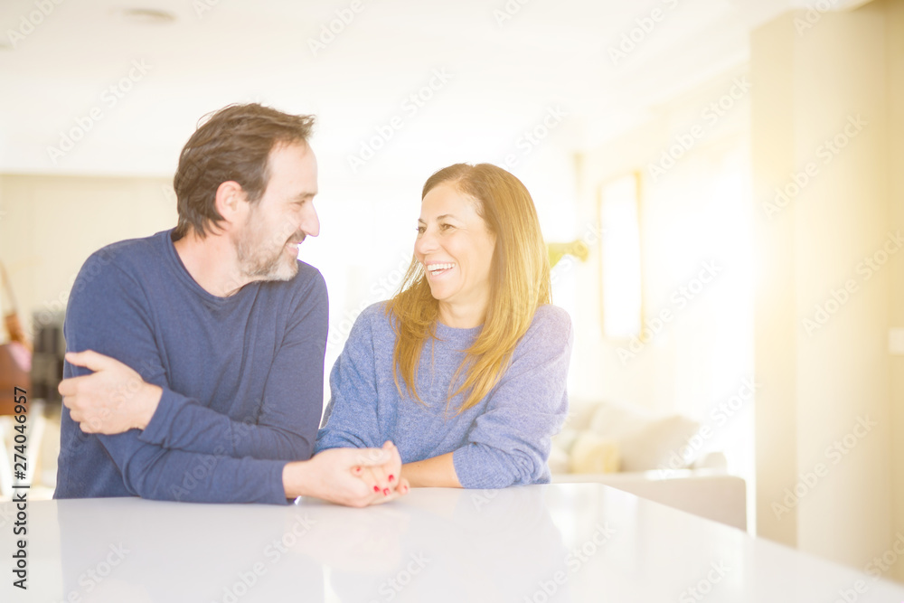 Romantic middle age couple sitting together at home Romantic middle age couple sitting together at home