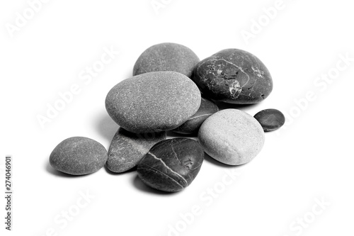 Scattered sea pebbles. Heap of smooth gray and black stones isolated on white background. Rounded rocks