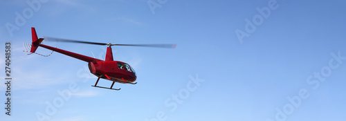 The aircraft - Red small helicopter makes flight low height