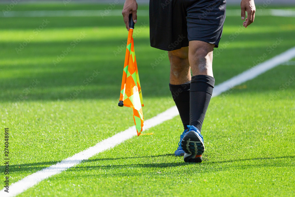 Football Assistant Referee walking with Flag
