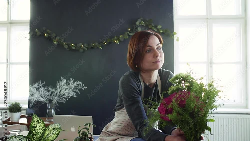 Young creative woman in a flower shop. A startup of florist business.