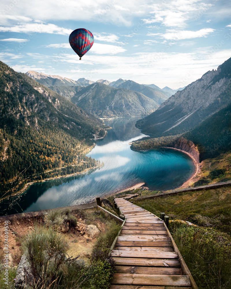 River in Austria alps. Vertical Wallpaper. With stairs leading down to a river and a balloon flying in the air. Partially cloudy day - obrazy, fototapety, plakaty 