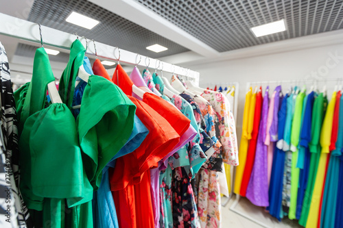 Cocktail dress. Clothing on hanger at the modern shop boutique. Bright multi-colored fabrics. concept of shopping.