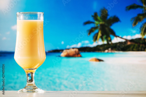 Glass of orange juice in tropical summer