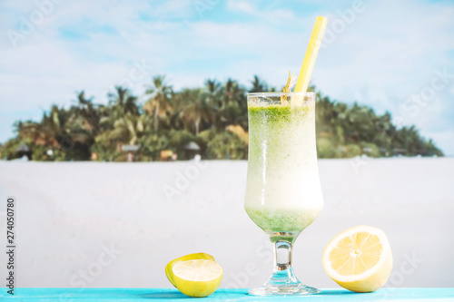 Glass of tropical sour smoothie and sliced citrus