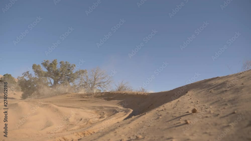Dune buggy kicking up dust on turn in mountains of Utah Dune buggy kicking up dust on turn in mountains of Utah