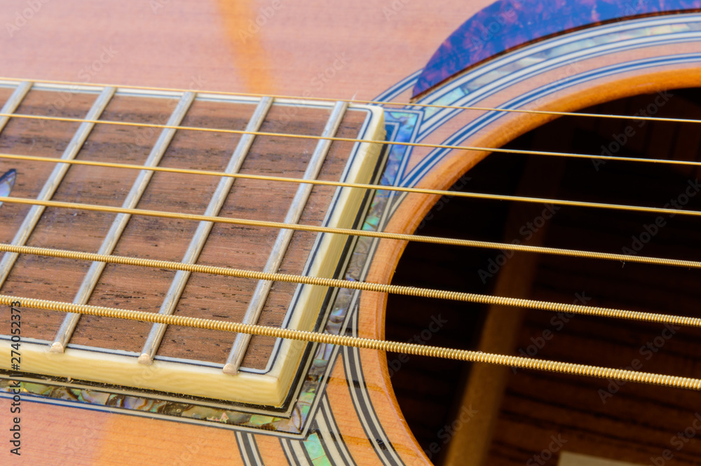 Acoustic guitar with sound clearance hole above strings