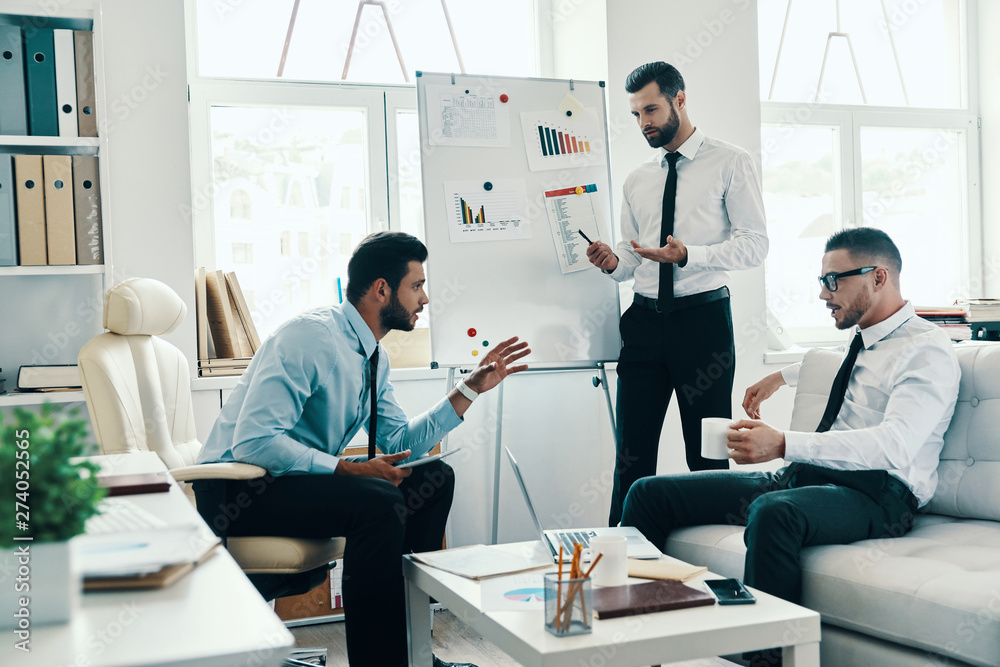 Inspired to work hard. Young modern man in formalwear conducting a business presentation using flipchart while working in the office