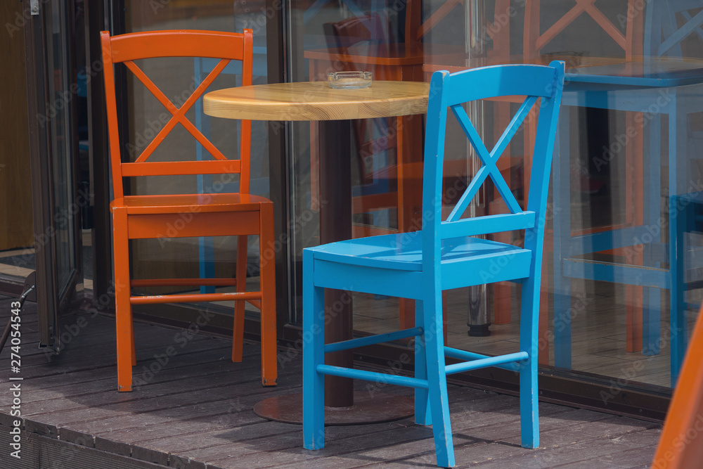 Multi-colored little tables and stools on the street Multi-colored little tables and stools on the street
