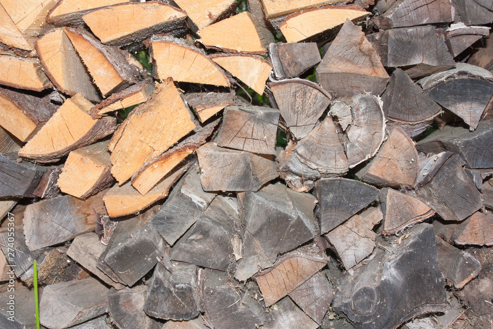 Wood for the village stove or fireplace stacked in a stack. Dry wood texture. Ecologically clean fuel. Selective focus. Wood for the village stove or fireplace stacked in a stack. Dry wood texture. Ecologically clean fuel. Selective focus.