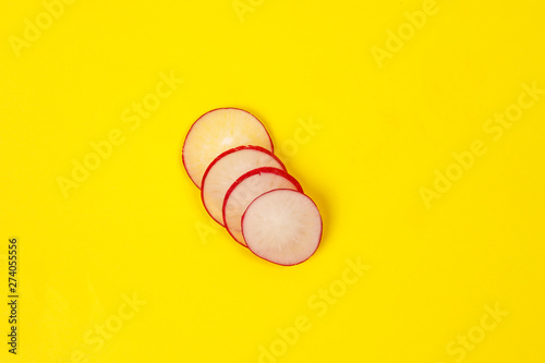 Small red radish on yellow background