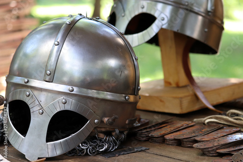 Medieval helmets on a wooden table. Armor of middle ages, knightly equipment, armory forge background