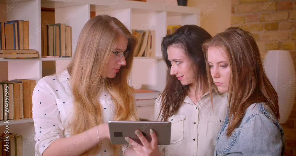 Closeup shoot of young beautiful lesbian couple talking to female realtor with tablet about purchasing an apartment Closeup shoot of young beautiful lesbian couple talking to female realtor with tablet about purchasing an apartment