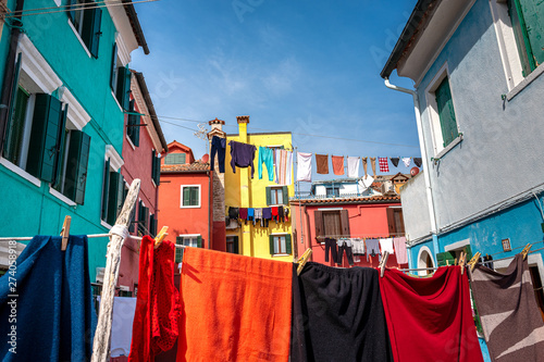 Wäsche zum trocknen hängt auf einer Leine zwischen den Wohnhäusern, Burano, Venedig © spuno