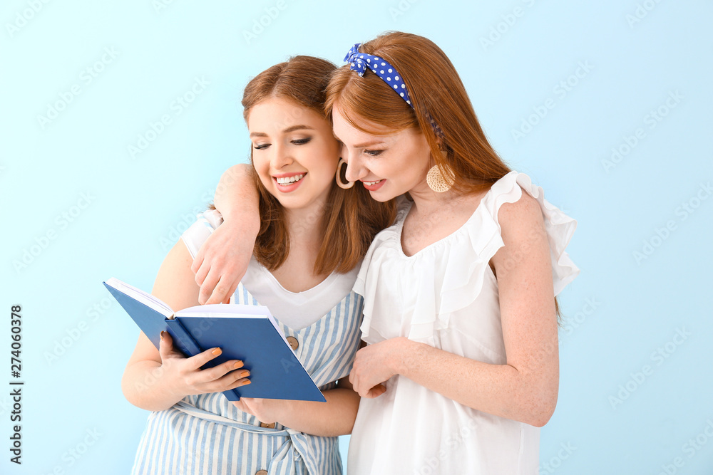 Portrait of beautiful young women with book on color background Portrait of beautiful young women with book on color background