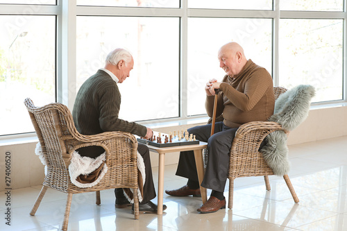 Senior men playing chess in...