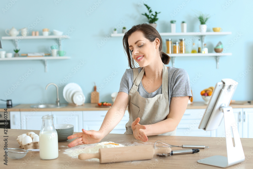 Beautiful young woman cooking pastry in kitchen Beautiful young woman cooking pastry in kitchen