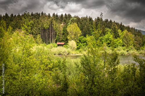 isolated dream house beside the lake, in dramatic stormy sky and wild nature, cerknica slovenia