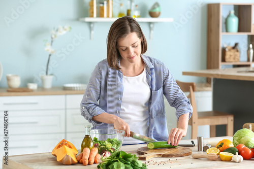 Young woman making salad in...