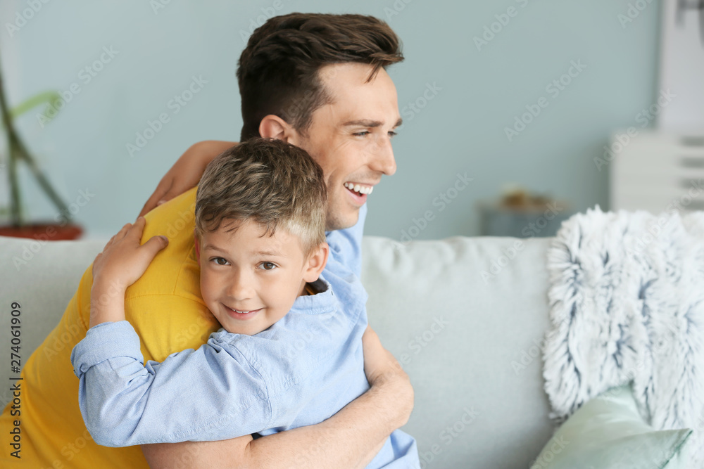 Portrait of happy father and son hugging at home Portrait of happy father and son hugging at home