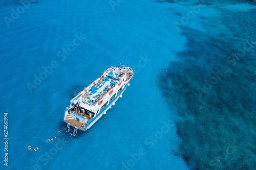 Aerial view of tropical island beach holiday yacht on blue reef ocean © smspsy