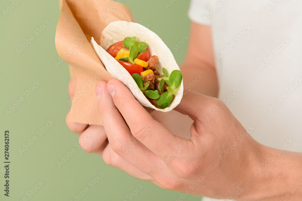 Man with tasty taco on color background, closeup Man with tasty taco on color background, closeup