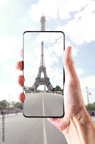 view on the Tour Eiffel: male hand holding a smartphone frame the Tower