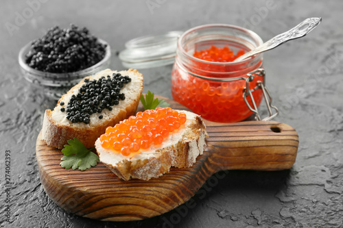 Sandwiches with delicious caviar on dark background photo