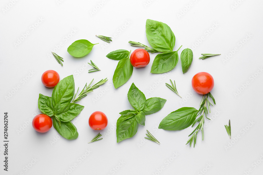 Fresh green basil, tomatoes and rosemary on white background Fresh green basil, tomatoes and rosemary on white background