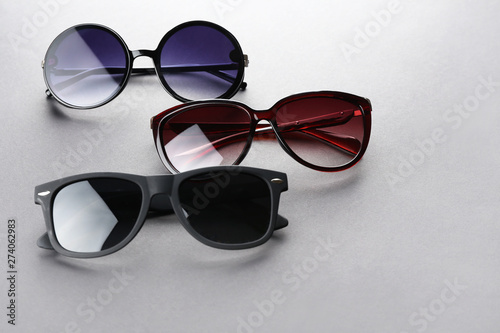 Modern sunglasses on grey background