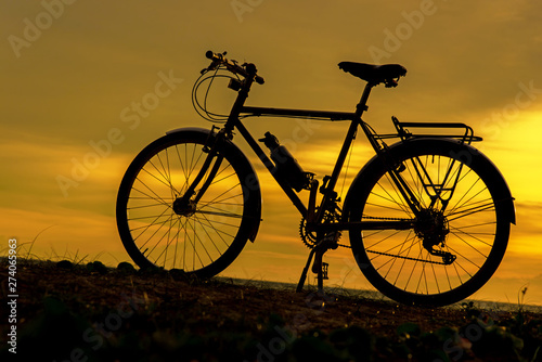 Silhouette biker at sunset over the beach. Lifestyle Concept.