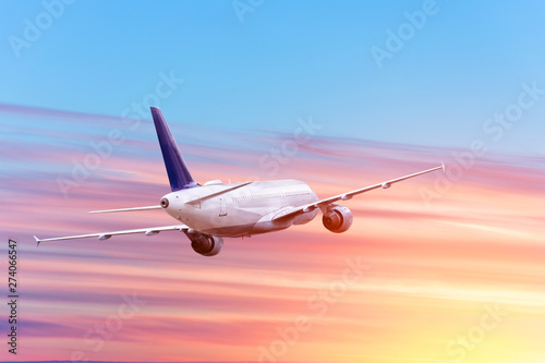 Passenger plane takes off against the backdrop of sunset and clouds.