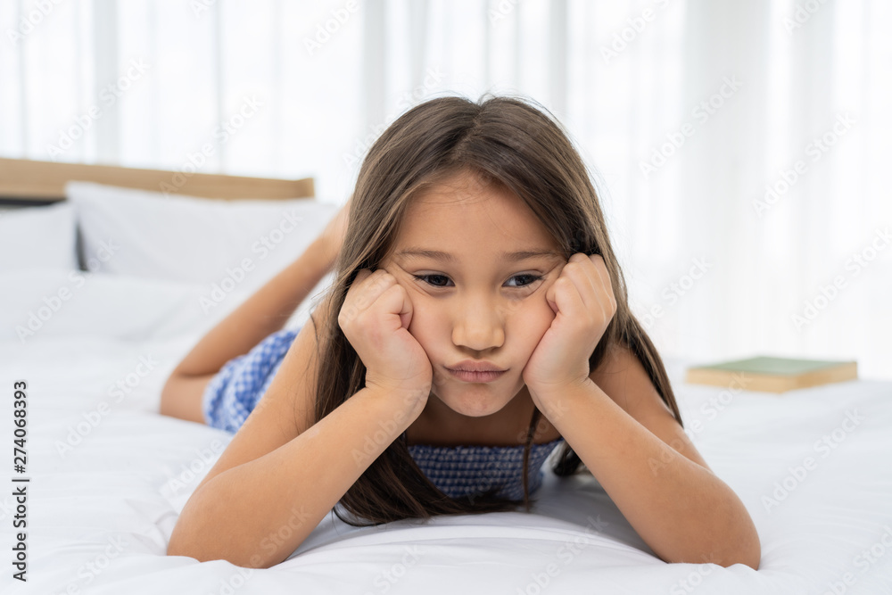Asian girl on a white bed are sad and unhappy.