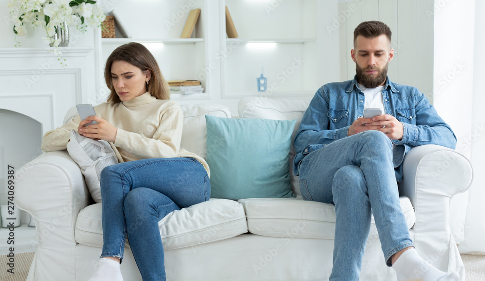 Family quarrel. Couple Staring At Their Own Smartphones Family quarrel. Couple Staring At Their Own Smartphones