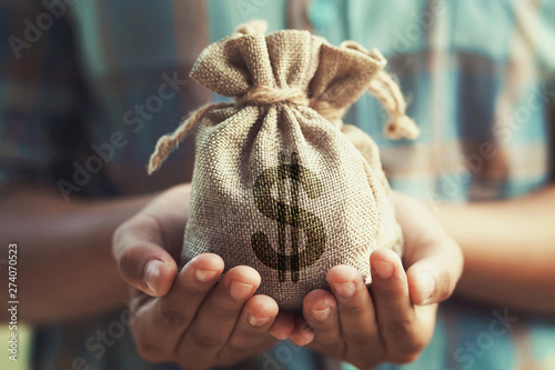 woman hand holding money bag. concept saving finance and accounting photo