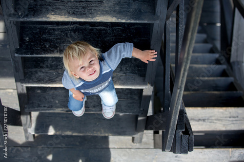 Child, toddler boy, sitting on wooden stairs © Tomsickova