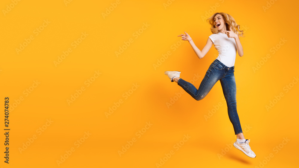 Joyful Woman Jumping And Pointing At Copy Space Joyful Woman Jumping And Pointing At Copy Space