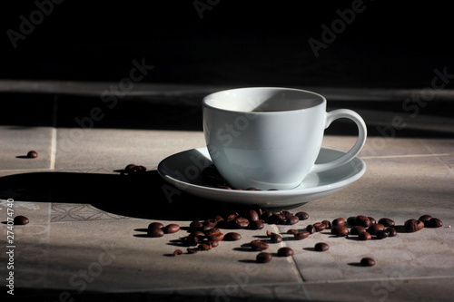 Coffee in a white glass, gray floor with morning light. 