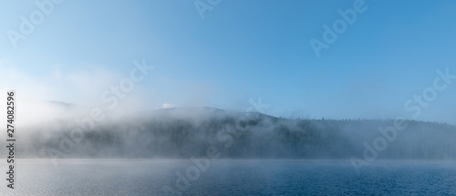 early morning mountains lake covered in fog 