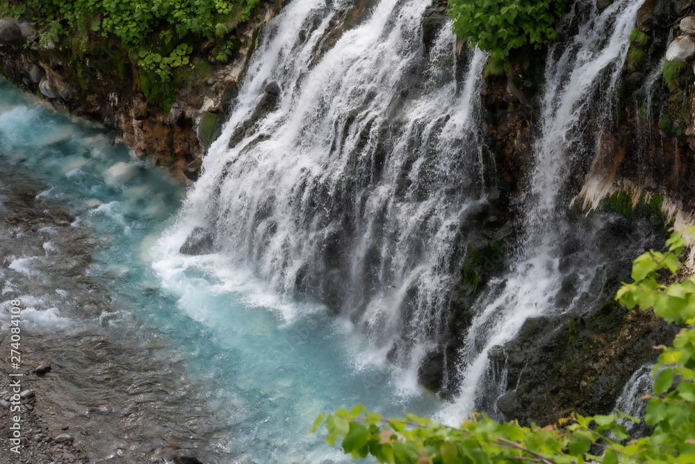Scenery of shirahige's waterfall and Biei river. The water of this river flows into the blue pond at the downstream. Biei Hokkaido, Japan Scenery of shirahige's waterfall and Biei river. The water of this river flows into the blue pond at the downstream. Biei Hokkaido, Japan