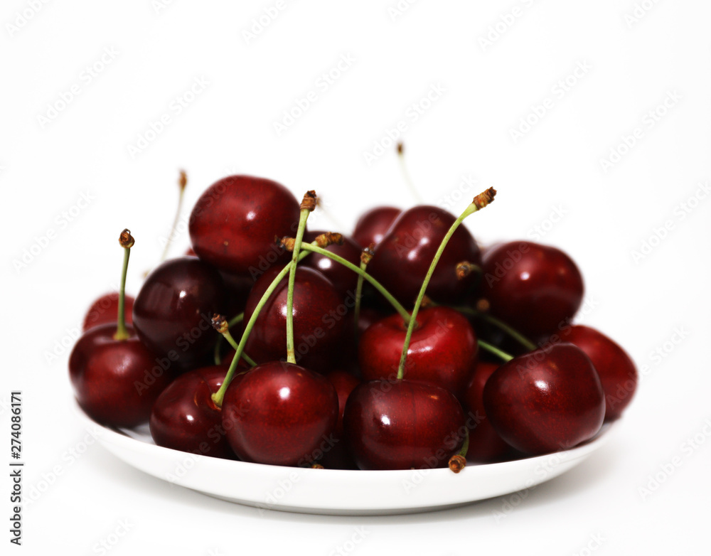A bunch of ripe cherries with peduncles lies on a white background. Large collection of fresh red cherries. Ripe cherries background isolate A bunch of ripe cherries with peduncles lies on a white background. Large collection of fresh red cherries. Ripe cherries background isolate