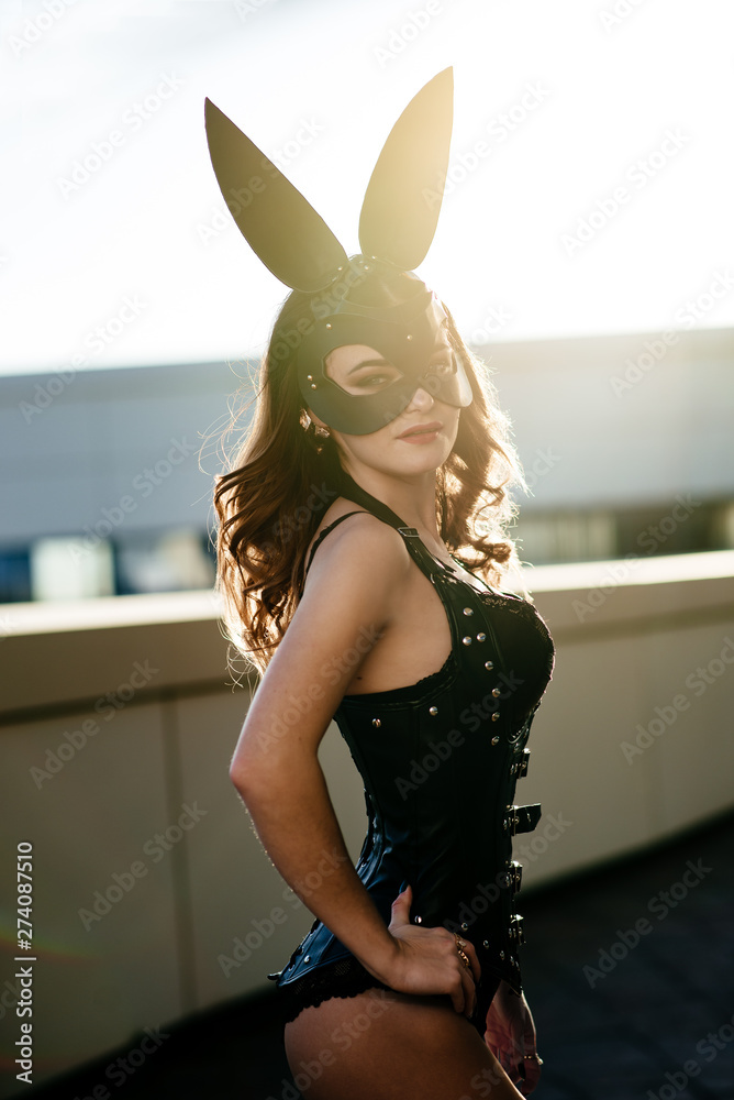 Cute sexy brunette with hooked ears of hare and sunglasses poses on pink  background Stock Photo | Adobe Stock