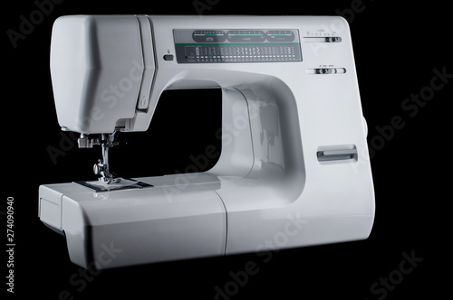 Electromechanical modern white plastic sewing machine on a black background, isolate