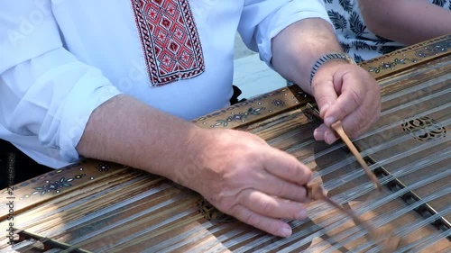 Editorial video. Yaremche city. Carpathians. Ukraine. June 15.2019. A man in folk clothes plays on the tsymbaly Ukrainian folk music instrument. photo