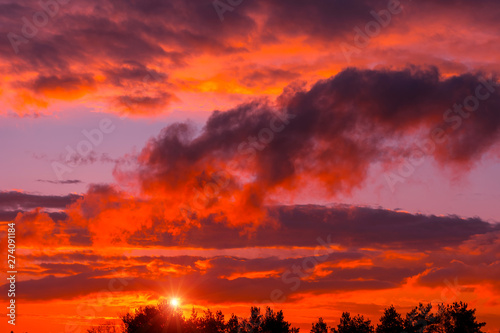 Fiery orange sunset  colorful and speckled  clouds. © Lumppini