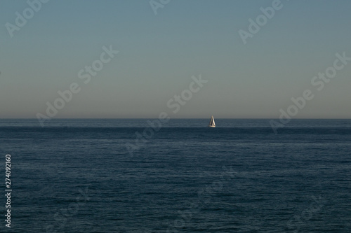 Sailing boat in the distance to the sea in the evening © Lyudmyla