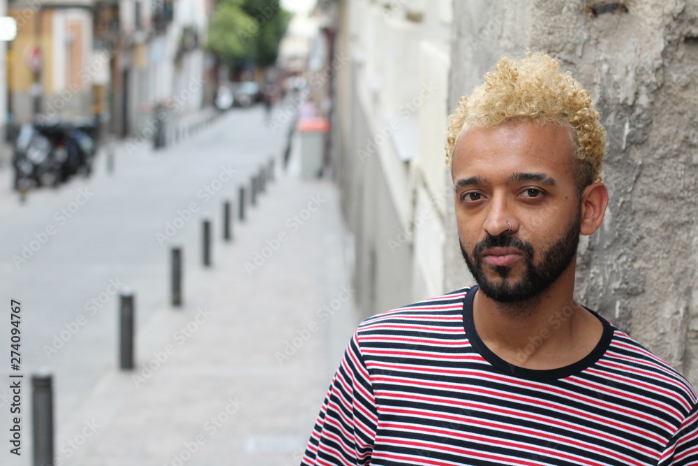 Man with blond dyed afro hair posing outdoors Man with blond dyed afro hair posing outdoors