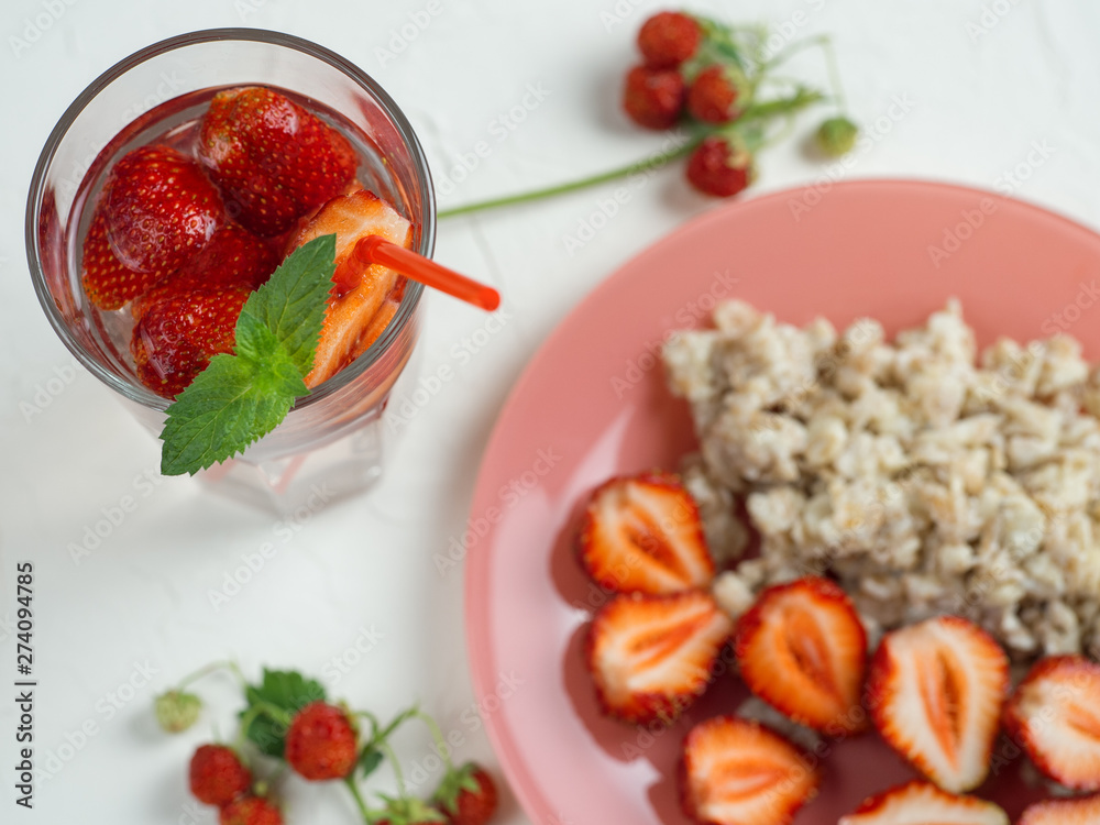 oatmeal with strawberries and strawberry lemonade on the white table oatmeal with strawberries and strawberry lemonade on the white table